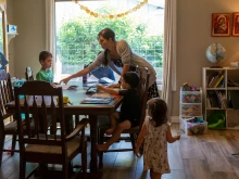 Maureen McKinley helps her children through some study exercises in her family's dining room in Phoenix. McKinley and her husband, Matt, home-school their five children and offer the older children a curriculum that includes Latin.